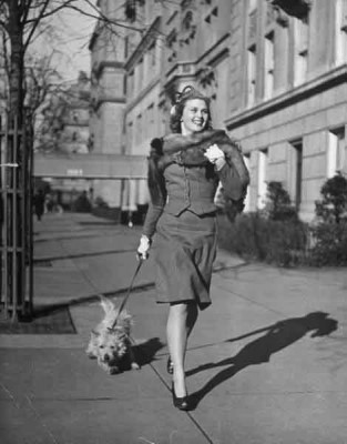 Actress-Joan-Caulfield-briskly-walking-her-West-Highland-terrier-Witty,-down-Fifth-Ave