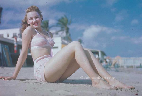 glamourdaze-woman-seated-on-beach-in-pink-bikini-1940