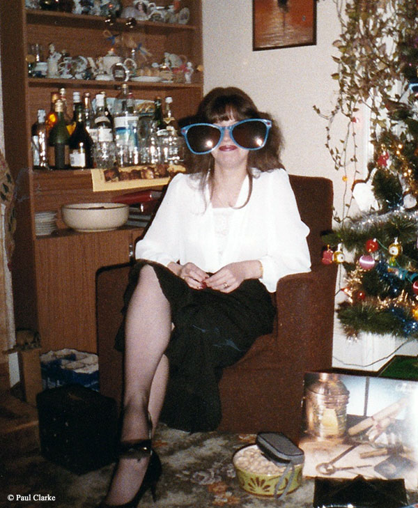 Christmas 1980's. Woman posing with silly sunglasses.
