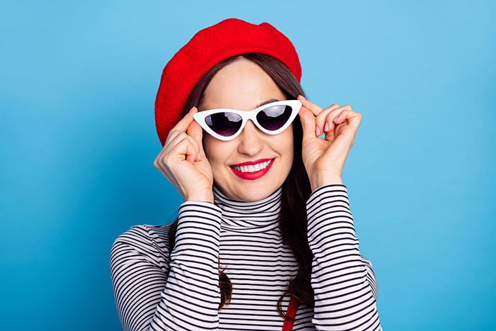 Vintage styled woman with breton top, beret and sunglasses.